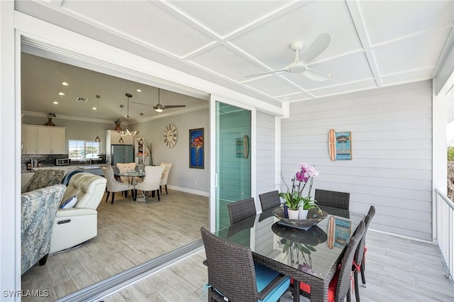 dining room with coffered ceiling, crown molding, ceiling fan, and light wood-type flooring