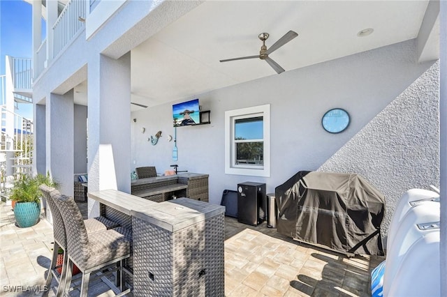 view of patio / terrace featuring ceiling fan and a bar