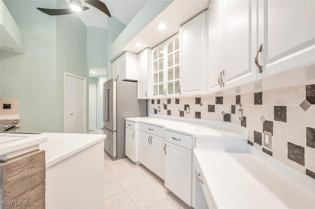 kitchen with tasteful backsplash, ceiling fan, stainless steel fridge, and white cabinets