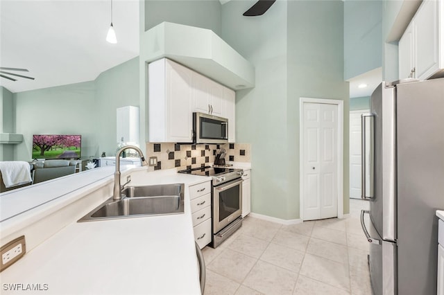 kitchen with sink, ceiling fan, stainless steel appliances, white cabinets, and decorative light fixtures