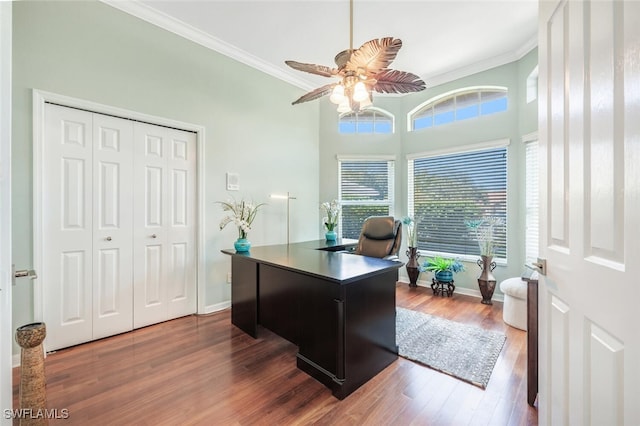 office space with dark wood-type flooring, ornamental molding, and ceiling fan