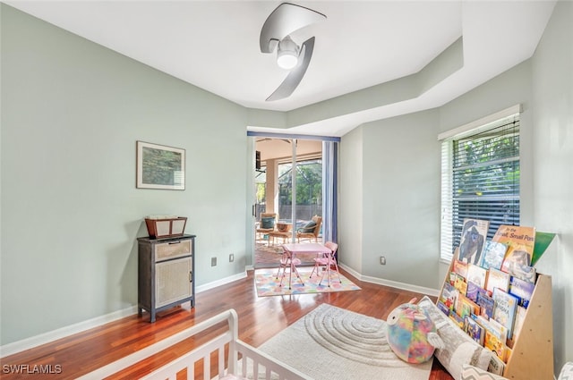 bedroom with ceiling fan, wood-type flooring, and access to exterior