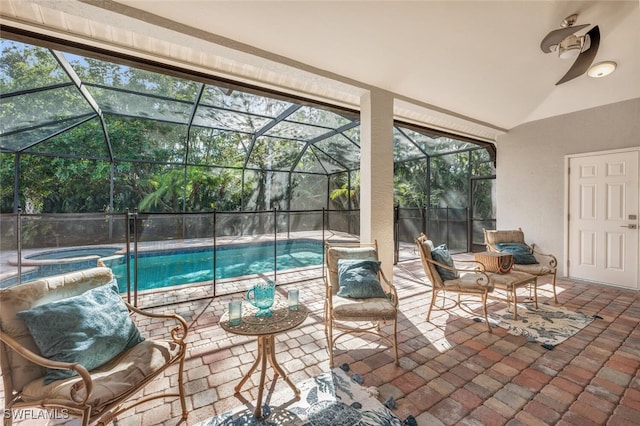 view of swimming pool with an in ground hot tub, a patio, and glass enclosure