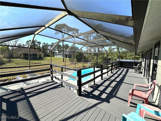 deck featuring a yard and glass enclosure