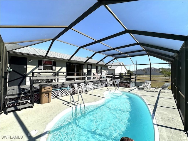 view of swimming pool featuring a lanai and a patio area