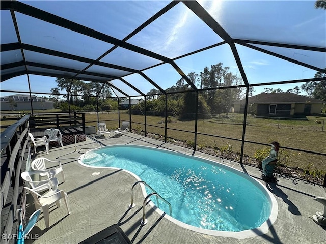 view of pool featuring a lanai, a patio area, and a lawn