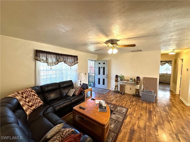 living room with ceiling fan, hardwood / wood-style floors, and a textured ceiling