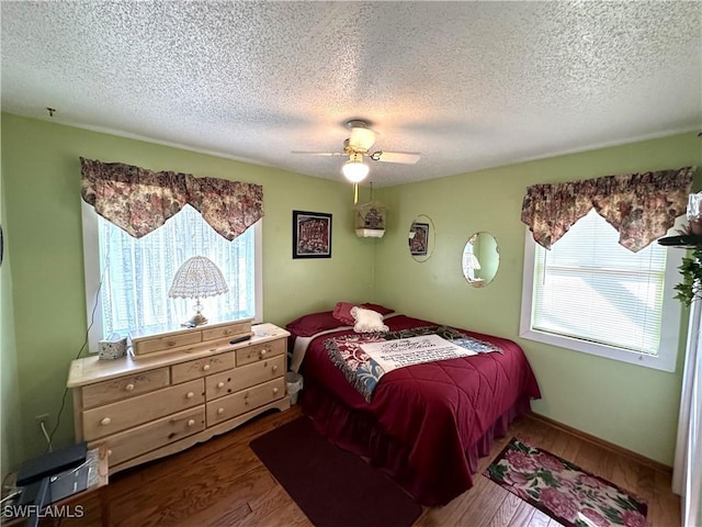 bedroom featuring hardwood / wood-style floors, a textured ceiling, and ceiling fan