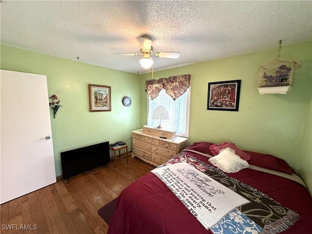 bedroom featuring wood-type flooring, a textured ceiling, and ceiling fan