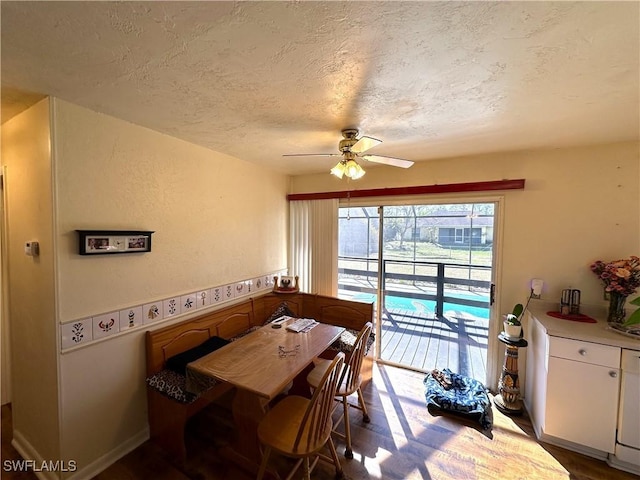 dining space featuring ceiling fan, hardwood / wood-style flooring, and a textured ceiling