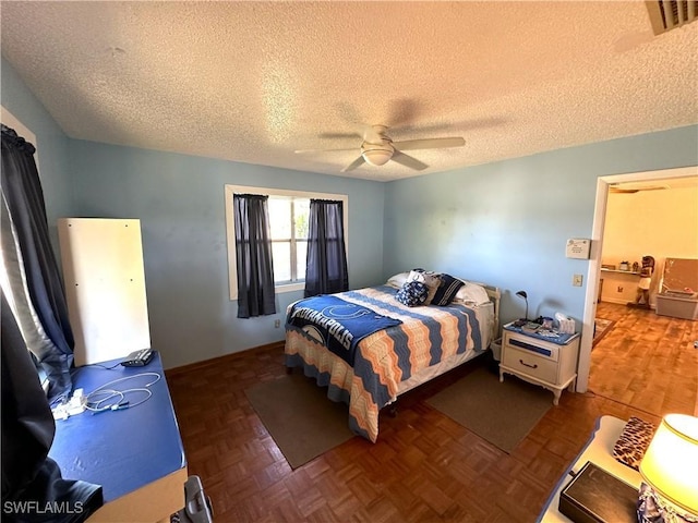 bedroom featuring dark parquet floors, a textured ceiling, and ceiling fan