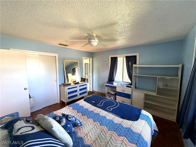 bedroom featuring dark hardwood / wood-style floors, a textured ceiling, a closet, and ceiling fan