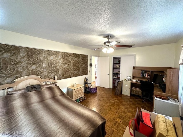 bedroom featuring ceiling fan, a closet, dark parquet flooring, and a textured ceiling