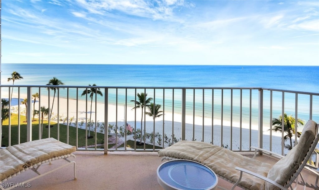 balcony featuring a water view and a view of the beach