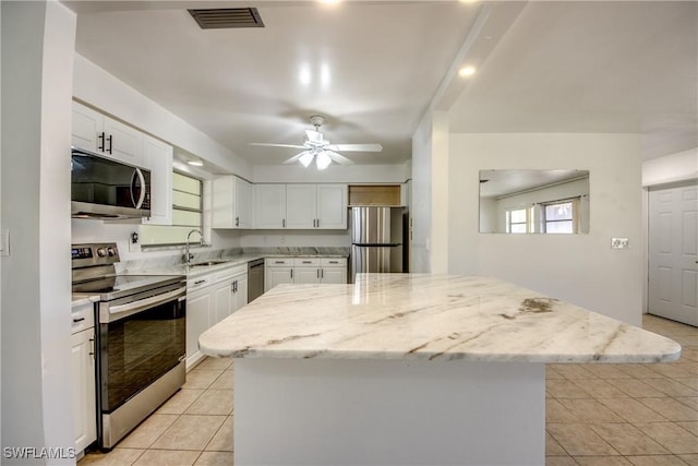 kitchen featuring white cabinetry, appliances with stainless steel finishes, sink, and a kitchen island