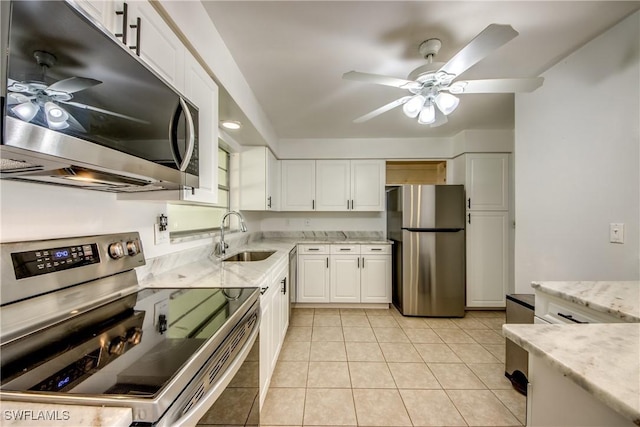 kitchen featuring sink, light tile patterned floors, ceiling fan, stainless steel appliances, and white cabinets