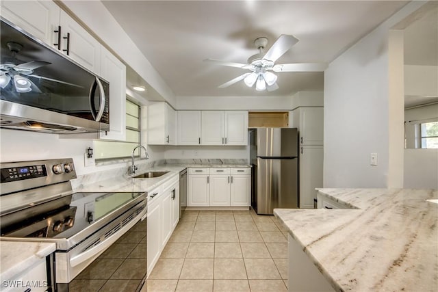 kitchen with sink, light tile patterned floors, ceiling fan, stainless steel appliances, and white cabinets