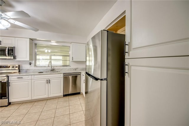 kitchen with sink, white cabinets, light tile patterned floors, ceiling fan, and stainless steel appliances