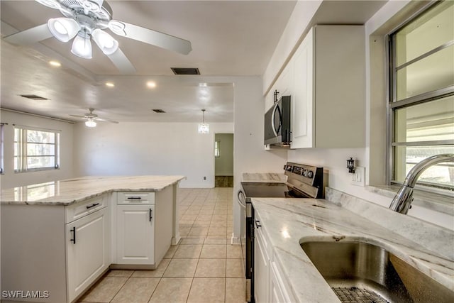 kitchen featuring stainless steel appliances, sink, white cabinets, and light stone counters