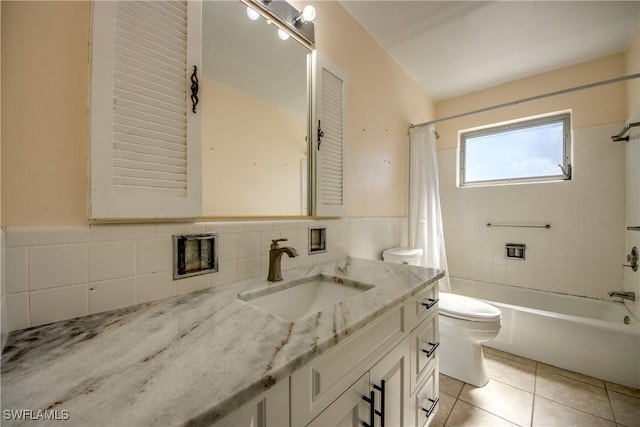 full bathroom with shower / tub combo with curtain, toilet, tile walls, vanity, and tile patterned flooring