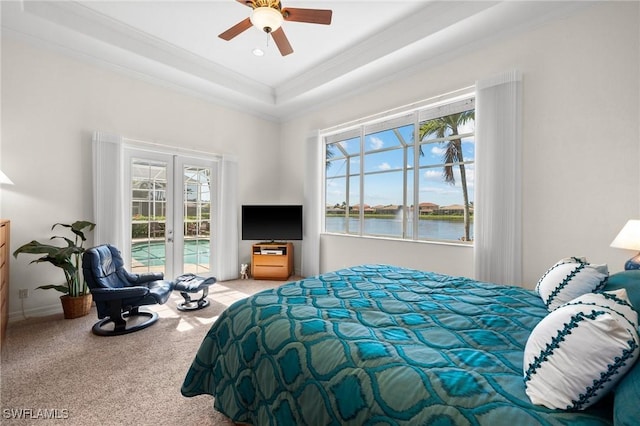 carpeted bedroom with french doors, access to exterior, a raised ceiling, and multiple windows