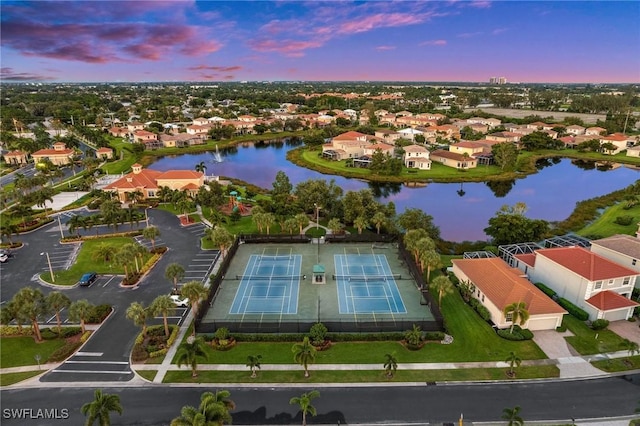 aerial view at dusk featuring a water view