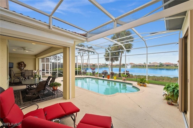 view of swimming pool with a patio, a water view, and glass enclosure