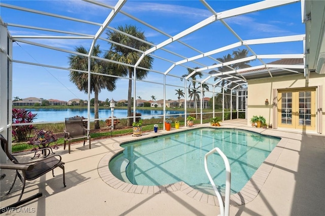 view of pool with a patio, a water view, glass enclosure, and french doors