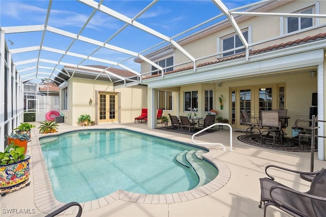 view of swimming pool featuring a lanai, a patio area, and french doors