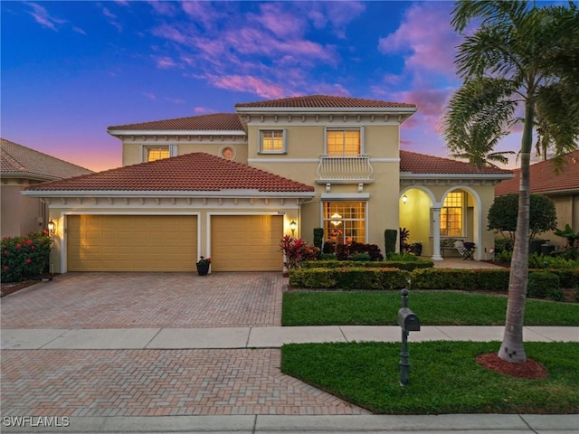 mediterranean / spanish-style house featuring a garage and a balcony