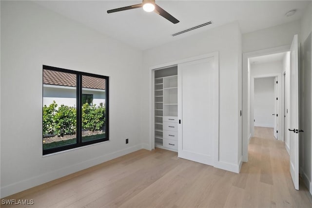 unfurnished bedroom with ceiling fan, a closet, and light wood-type flooring