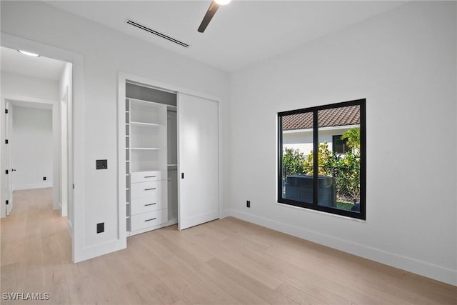 unfurnished bedroom featuring light hardwood / wood-style floors, a closet, and ceiling fan