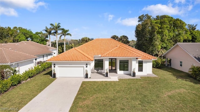 mediterranean / spanish-style house featuring a garage and a front lawn