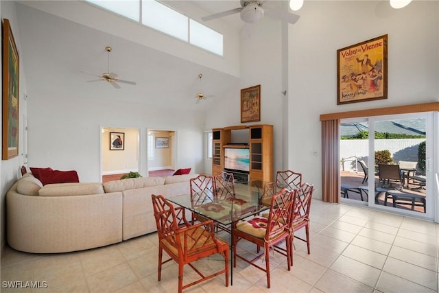 dining space featuring light tile patterned floors, a towering ceiling, and ceiling fan