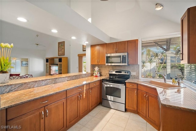 kitchen featuring a healthy amount of sunlight, stainless steel appliances, kitchen peninsula, and sink