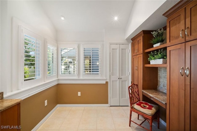 interior space featuring lofted ceiling and light tile patterned floors