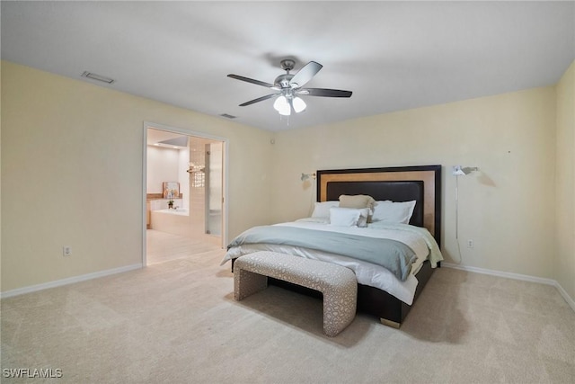 bedroom with ceiling fan, light colored carpet, and connected bathroom