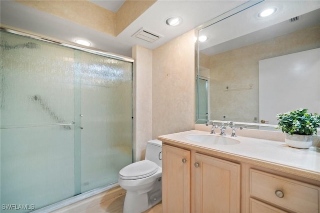 bathroom featuring vanity, an enclosed shower, hardwood / wood-style flooring, and toilet