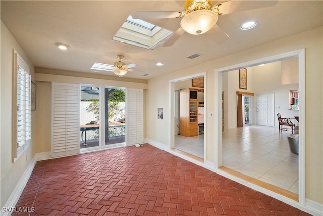 unfurnished room featuring ceiling fan and a skylight