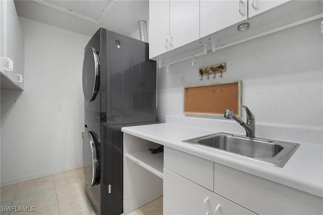 laundry room featuring cabinets, stacked washer and dryer, sink, and light tile patterned floors