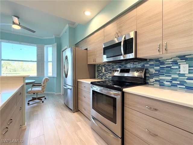 kitchen featuring crown molding, ceiling fan, appliances with stainless steel finishes, and decorative backsplash