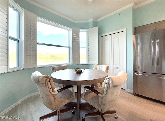 dining area with ornamental molding and light hardwood / wood-style floors