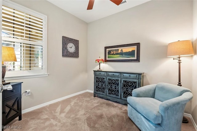 living area with ceiling fan and light colored carpet