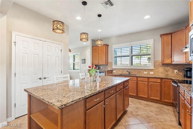 kitchen featuring sink, stainless steel range with electric stovetop, a center island, tasteful backsplash, and decorative light fixtures