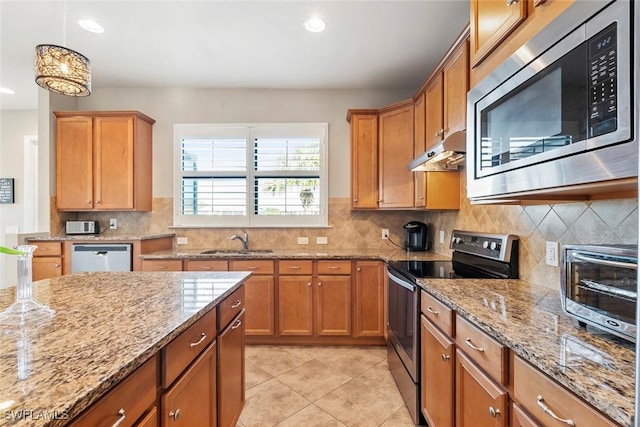 kitchen with light stone countertops, appliances with stainless steel finishes, sink, and backsplash