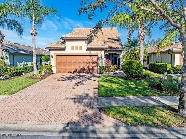 mediterranean / spanish-style home with a garage and a front lawn