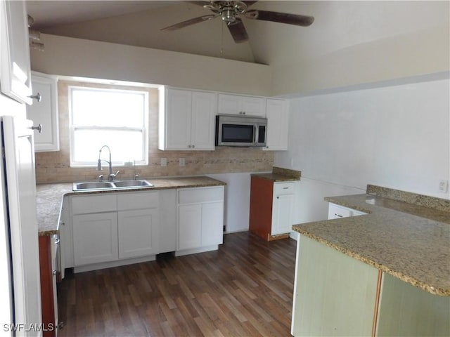 kitchen with sink, light stone counters, dark hardwood / wood-style flooring, white cabinets, and backsplash