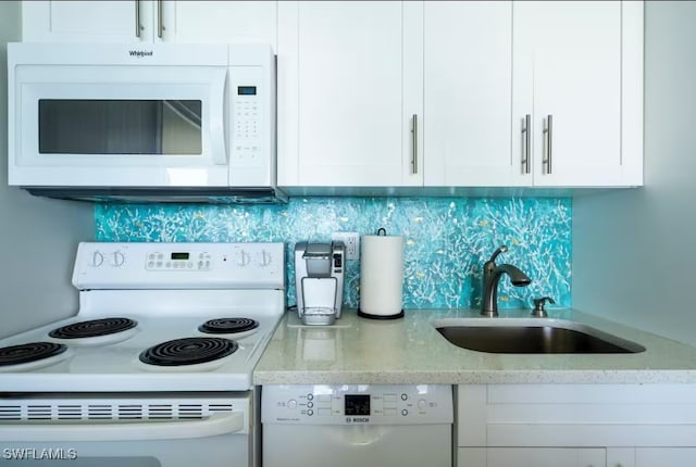 kitchen featuring white cabinetry, white appliances, and sink