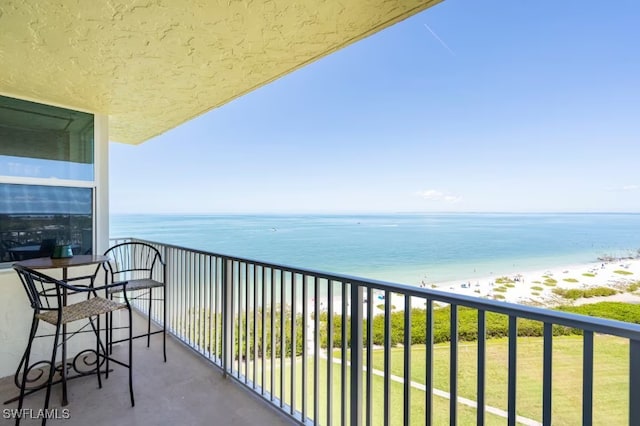 balcony featuring a water view and a beach view