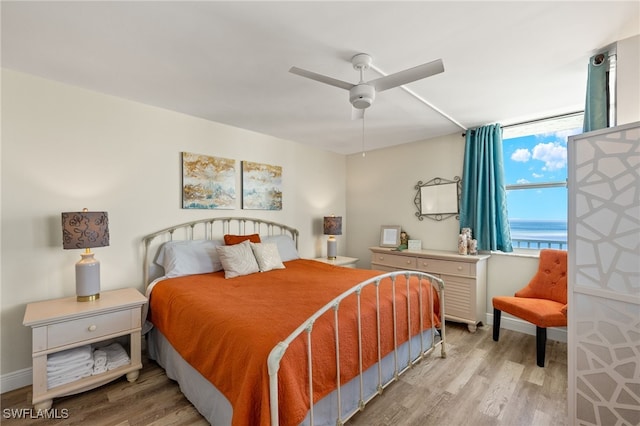 bedroom with a ceiling fan, baseboards, and wood finished floors